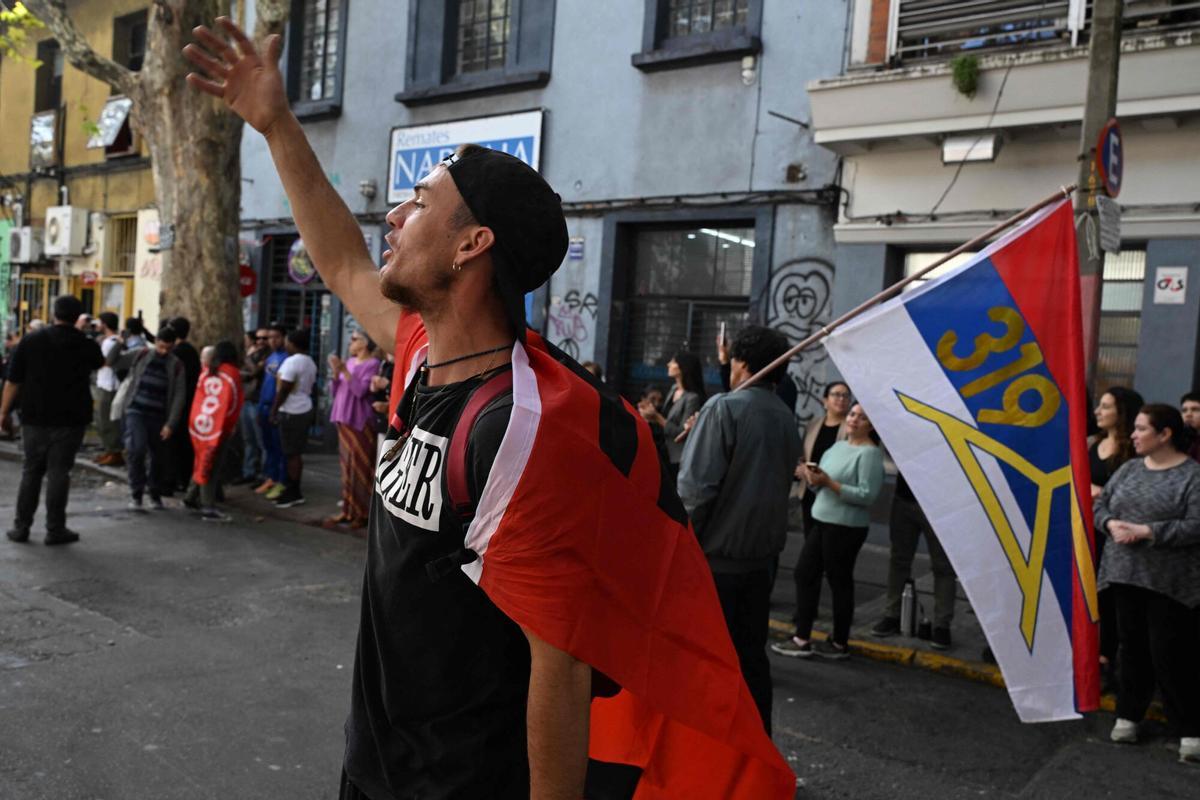 A young man gestures during the funeral cortege of Uruguays former President Jose Pepe Mujica in downtown Montevideo, on May 14, 2025, a day after his death. Mujica, an ex-guerrilla fighter and hero of the Latin American left, died on May 13, 2025 at the age of 89. The humble leader -- who once spent a dozen years behind bars for revolutionary activity -- lost his battle against cancer after announcing in January the disease had spread and he would stop treatment. (Photo by Eitan ABRAMOVICH / AFP)