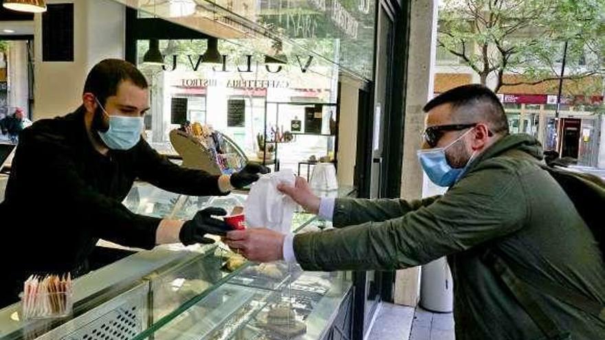 Un italiano recoge café de un puesto callejero en Nápoles.