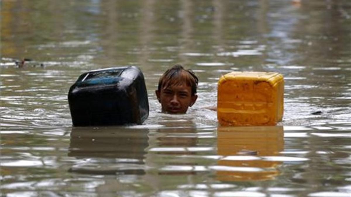 Uno de los miles de afectados por las lluvias torrenciales que han afectado a Birmania espera la llegada de los efectivos de rescate.