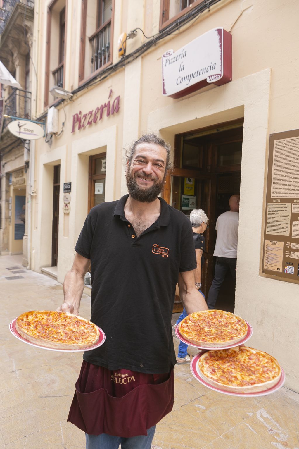 Unai  Lejarza, con unas pizzas, en la  céntrica calle de La Fruta, en Avilés.