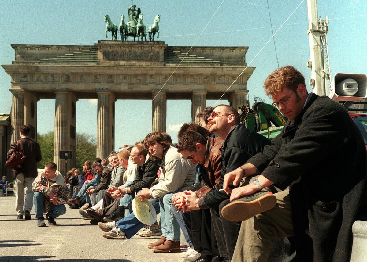 AP -SVEN KAESTNER-19/04/99-BERLIN- Jobless workers and workers of middle-class building firms sit in front of the Brandenburg Gate during a demonstration in Berlin Monday, April 19, 1999. They protest against illicit work in connection with the reconstruction of the nearby Reichstag building, where the German parliament met for the first session. (AP Photo/Sven Kaestner) AP -SVEN KAESTNER-19/04/99-BERLIN- Jobless workers and workers of middle-class building firms sit in front of the Brandenburg Gate during a demonstration in Berlin Monday, April 19, 1999. They protest against illicit work in connection with the reconstruction of the nearby Reichstag building, where the German parliament met for the first session. (AP Photo/Sven Kaestner)