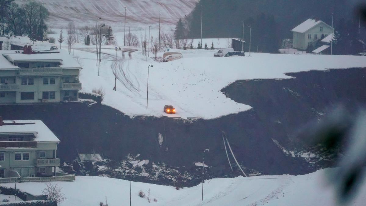 Un coche se detiene en el filo de un socavón provocado por el corrimiento de tierra en Gjerdrum, en Noruega.