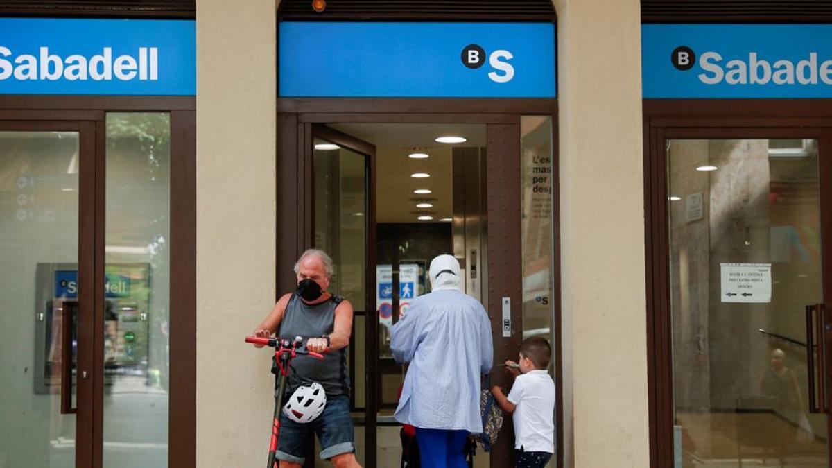 Usuarios acceden a una sucursal de Banco Sabadell.
