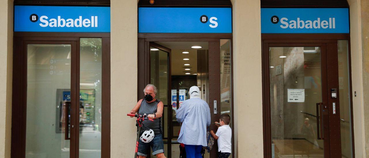 Usuarios acceden a una sucursal de Banco Sabadell.
