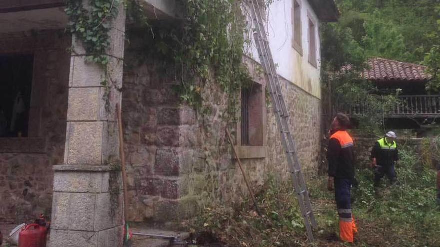 Operarios del Ayuntamiento de Cangas de Onís limpian la casona de Les Llanes, en Covadonga.