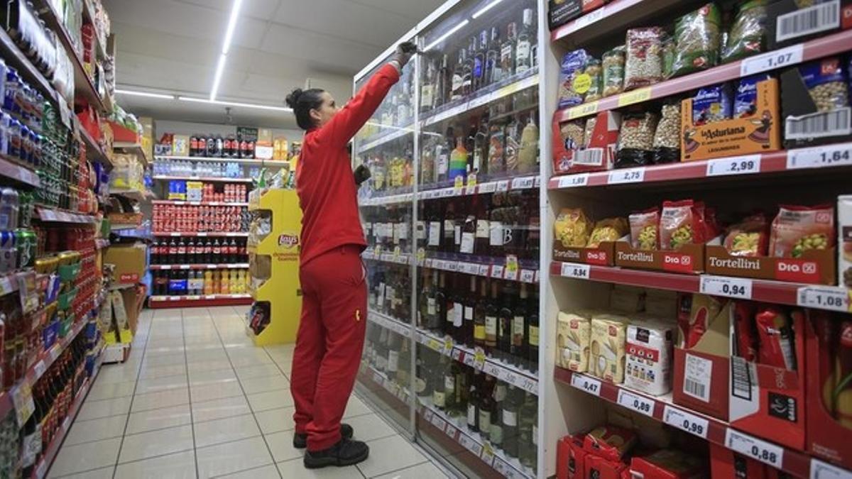 Una empleada repone los productos en un supermercado de Barcelona