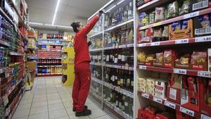  Una empleada repone los productos en un supermercado.