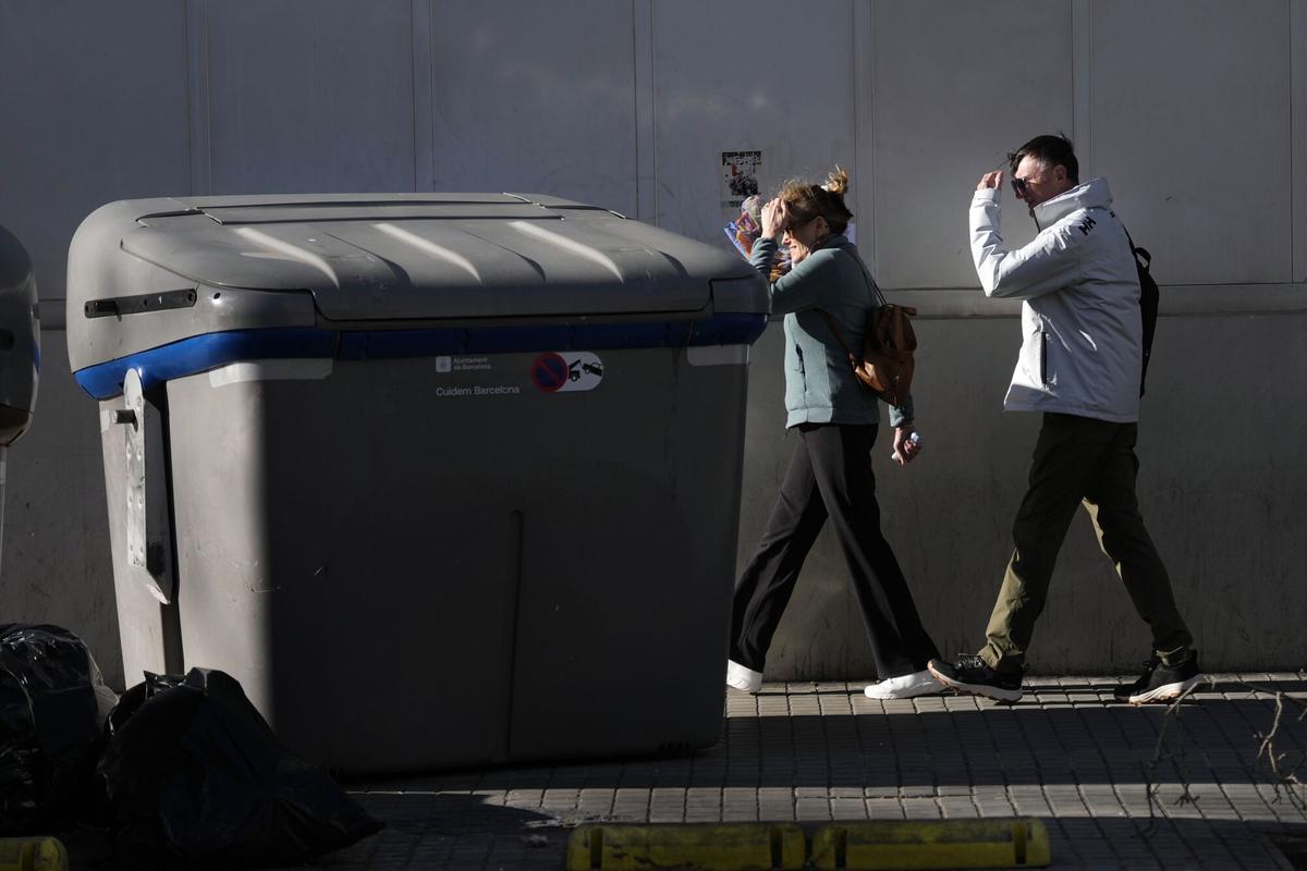 Un contenedor arrastrado en una acera este jueves cuando Cataluña afronta una jornada de vientos huracanados, que alcanzan los 100 kilómetros por hora en algunas zonas, lo que ha llevado al Govern a suspender las clases en escuelas y universidades y la actividad sanitaria no urgente. EFE/Enric Fontcuberta