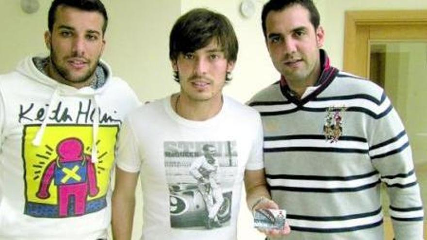 David Silva, en el centro, posa con el carné de socio del Caudal junto al fisio mierense Eduardo Álvarez, a la derecha.