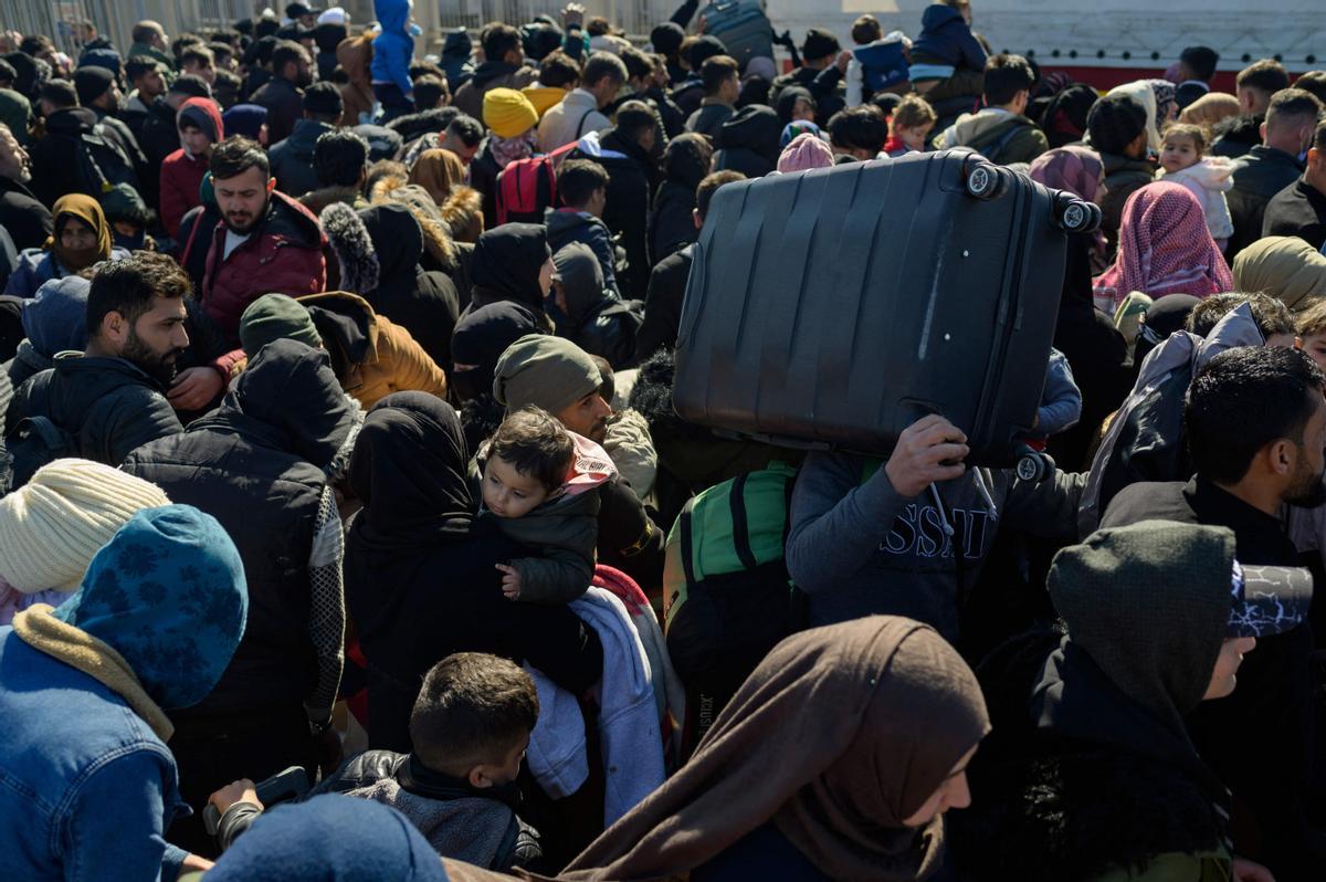 Los residentes sirios de la ciudad de Hatay esperan para cruzar la frontera entre Turquía y Siria después de que se vieron afectados por el terremoto de magnitud 7,8 que asoló la región hace casi dos semanas, en la puerta fronteriza de Cilvegozu