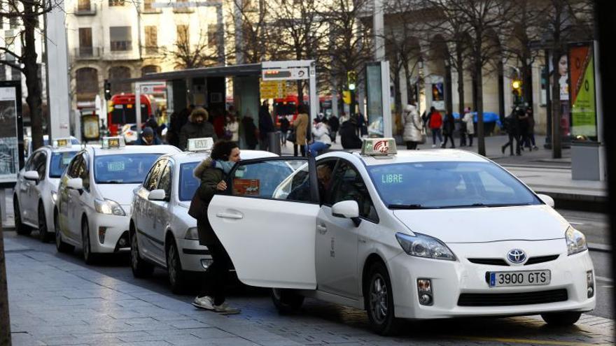 Una mujer se sube a un taxi en la parada del paseo Independencia de Zaragoza.  | JAIME GALINDO