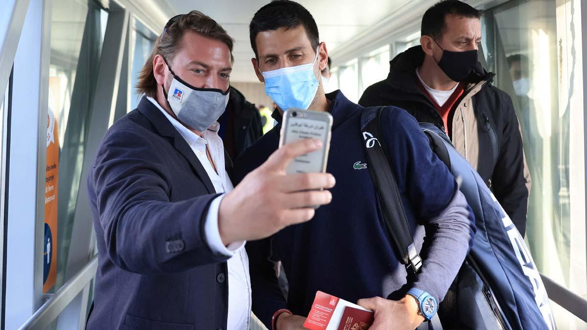 Un hombre se toma un selfi con el tenista Novak Djokovic a su llegada al aeropuerto de Belgrado.