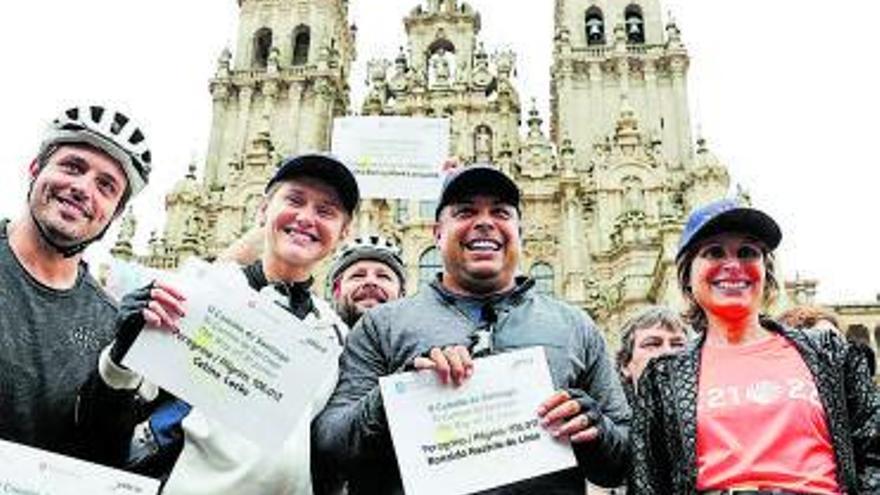 Ronaldo y su equipo con la ‘compostela’ y Nava Castro (d.). Abajo, el astro haciéndose ‘selfies’ con sus admiradores.  | // EFE / EUROPA PRESS