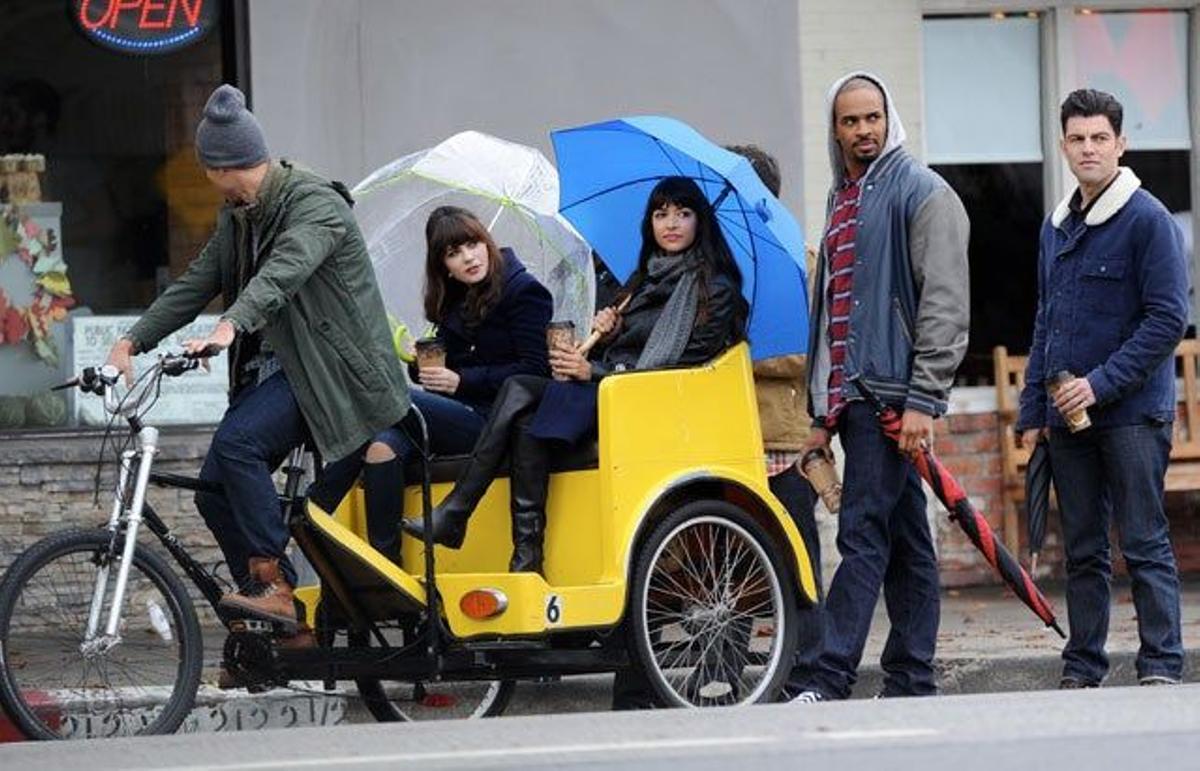 Zooey Deschanel y Hannah Simone en un pedicab y sus compañeros de Max Greenfield y Damon Wayans Jr, al lado de pie