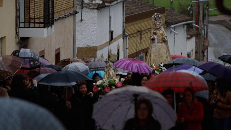 Procesión de la Virgen del Rosario en medio de los paraguas en Villabuena del Puente