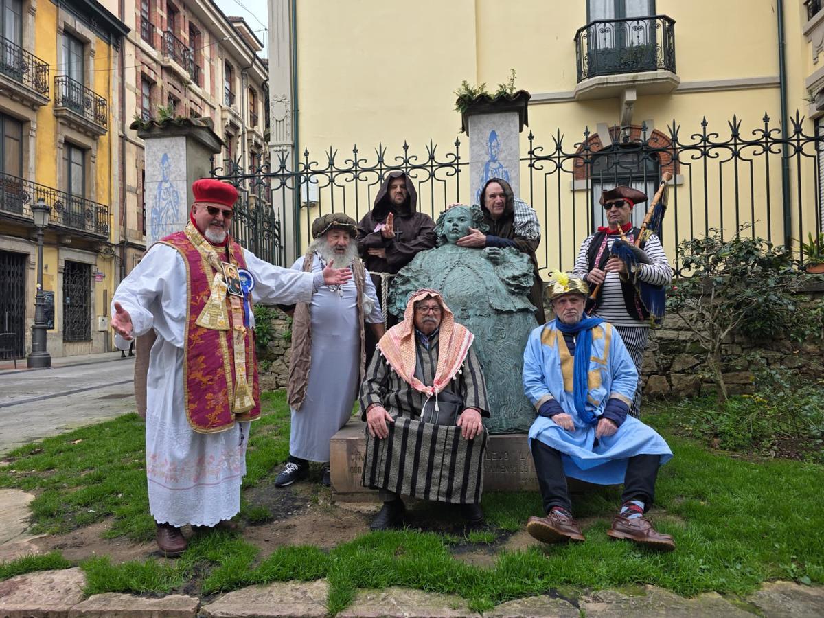 Los miembros de la Cofradía del Santo Entierro de la Sardina de Avilés junto a la estatua de "La Monstrua"