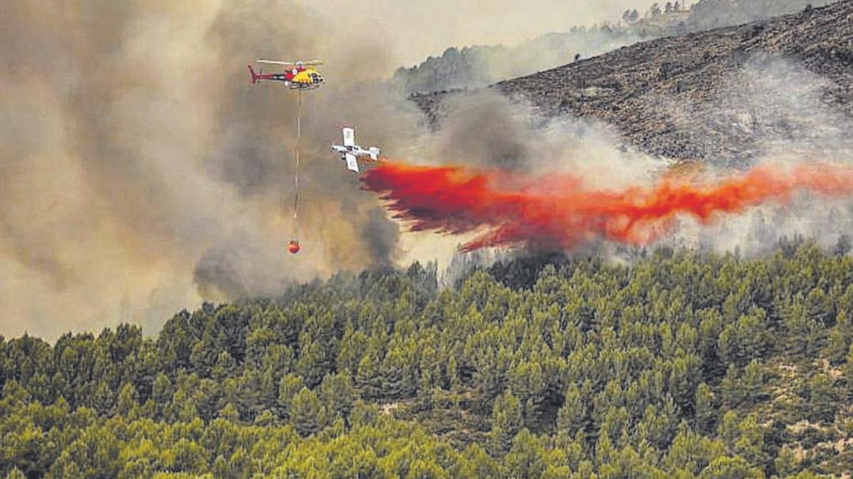Un avión descarga retardante junto a un helicóptero durante el incendio de Bejís, declarado el pasado 15 de agosto. | MEDITERRÁNEO