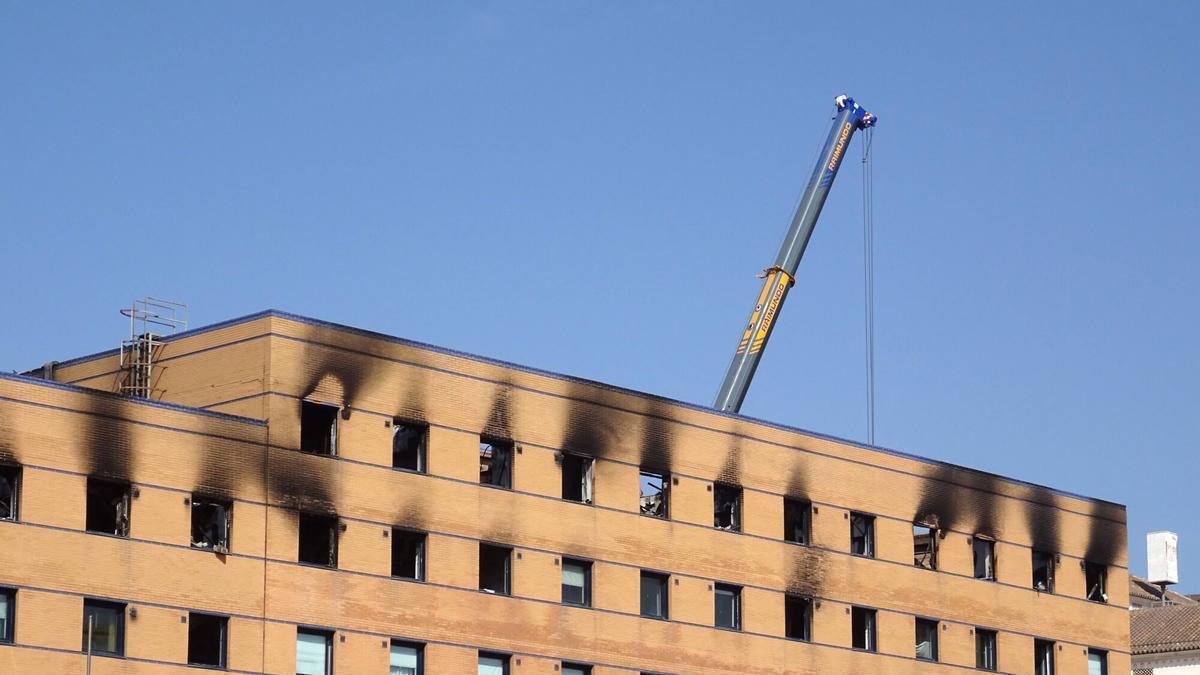 Varios operarios inician los preparativos para el derrumbe del hotel Ibis, destruido por un incendio.