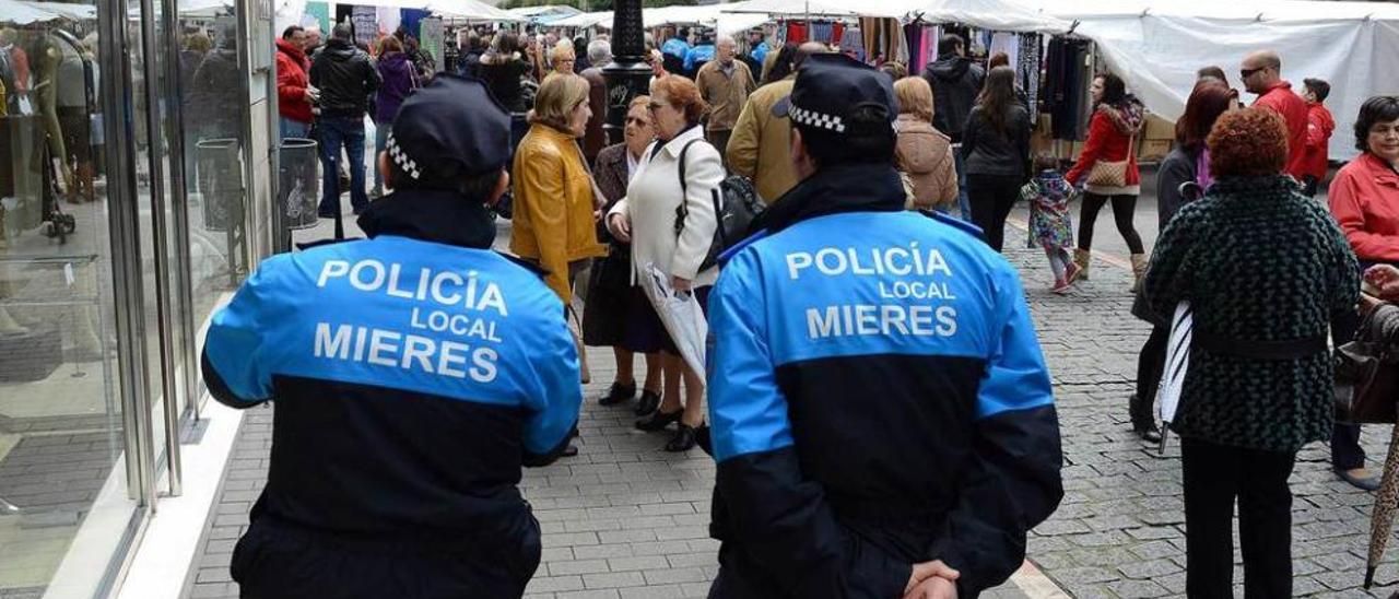 Dos policías locales, patrullando por el mercado dominical de Mieres.