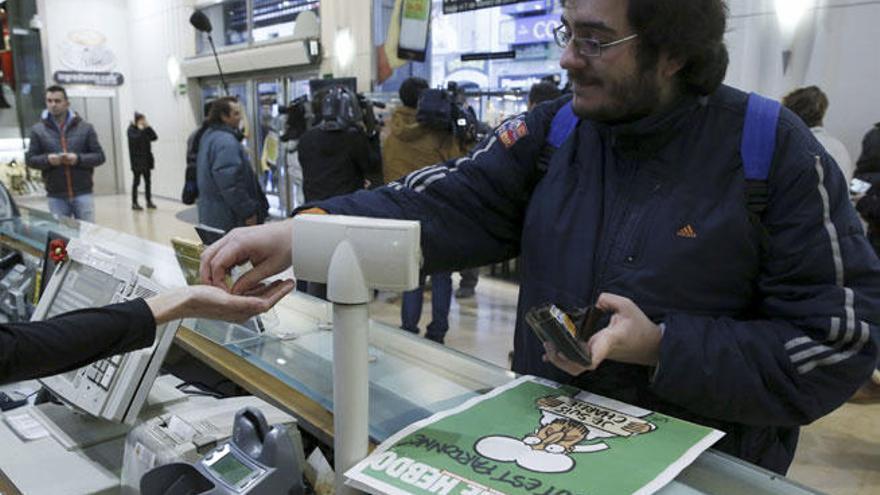 Un hombre compra el nuevo número de 'Charlie Hebdo' en un kiosco de Madrid.