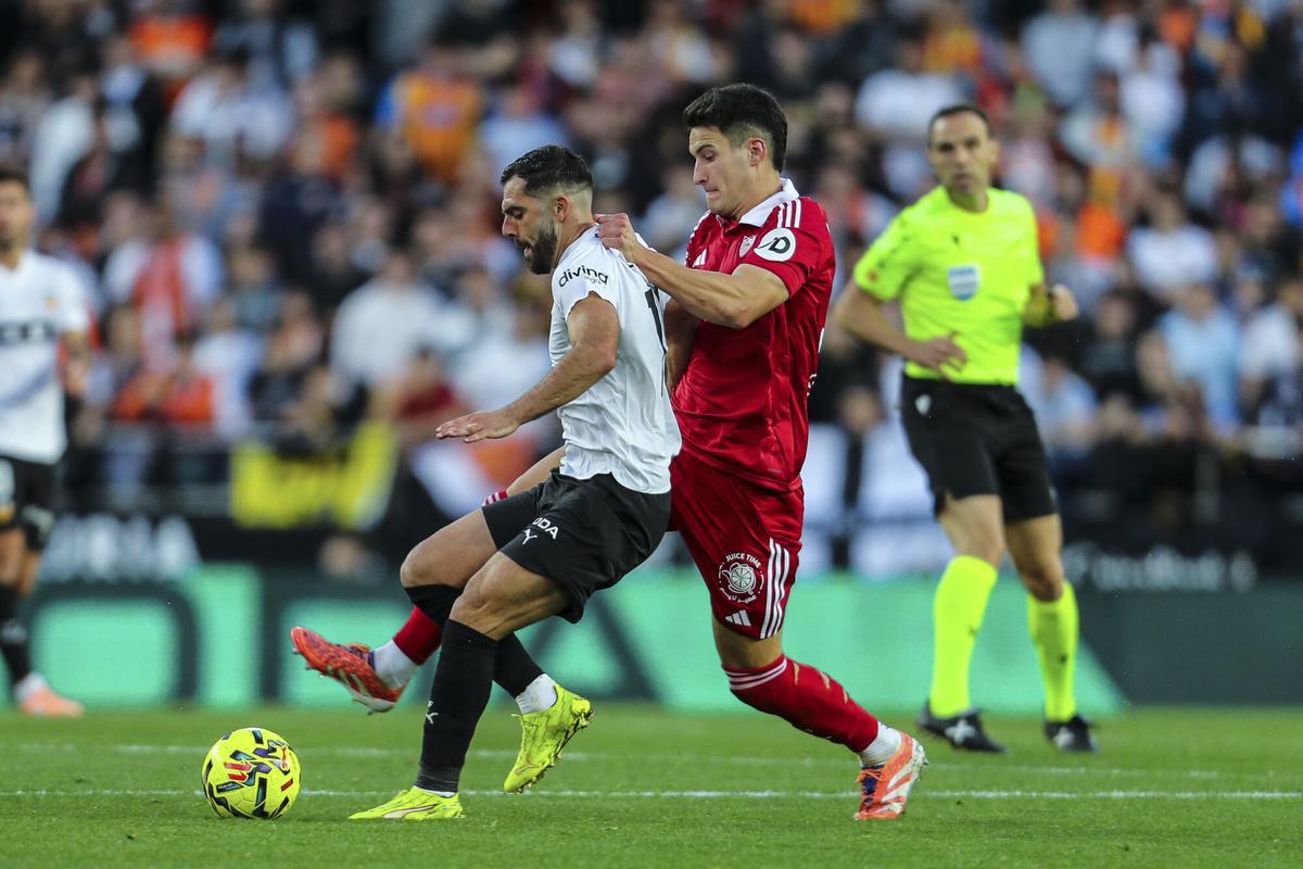 Luis Rioja y Castrín luchan por un balón en el Valencia CF-Sevilla FC en Mestalla de LaLiga EA Sports.