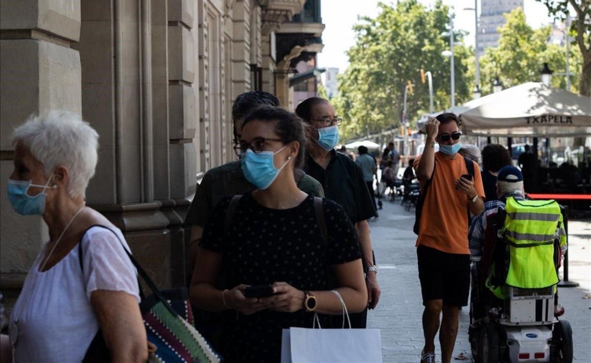 Gente con mascarilla en el paseo de Gràcia de Barcelona.