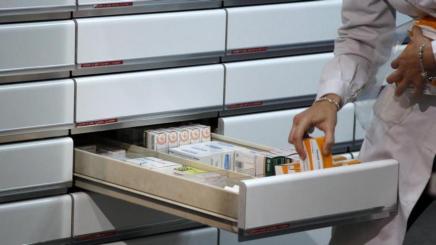 Una farmacéutica busca unos medicamentos.