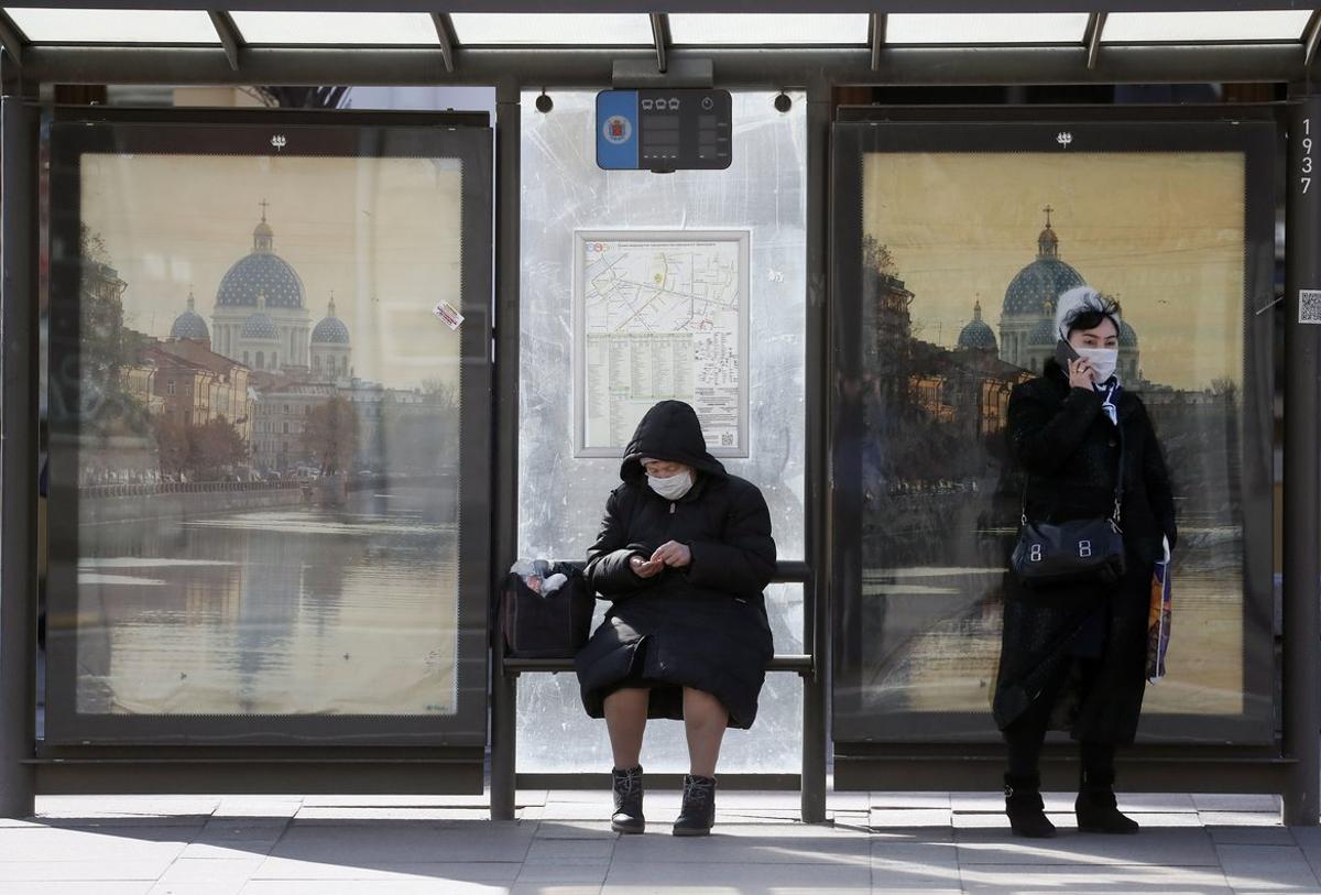 St. Petersburg (Russian Federation), 07/04/2020.- Women with a protective face masks seen in a bus-stop in St. Petersburg, Russia, 07 April 2020. Russian authorities have extended the national lockdown with stay-at-home orders until the end of April in a bid to quell the spread of the COVID-19. (Rusia, San Petersburgo) EFE/EPA/ANATOLY MALTSEV