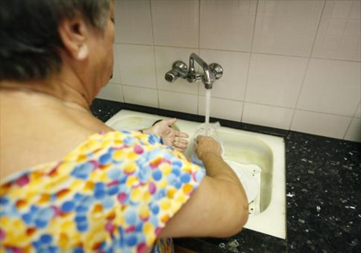 Una mujer friega los platos, en una imagen de archivo tomada en Barcelona.