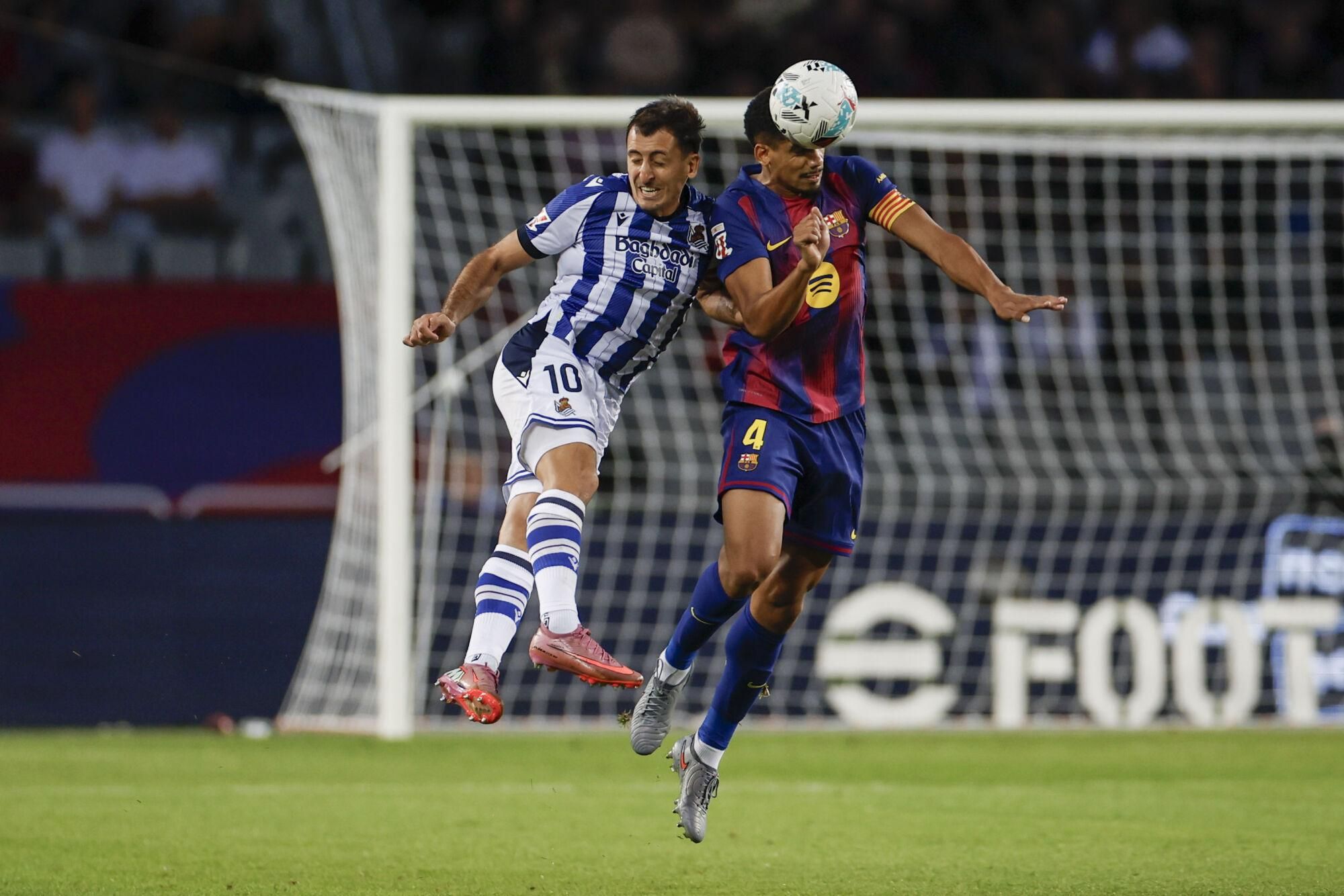 BARCELONA, 28/09/2025.- El delantero de la Real Sociedad, Mikel Oyarzabal (i), disputa el balón ante el defensa uruguayo del FC Barcelona, Ronald Araujo, durante el encuentro correspondiente a la séptima jornada de Liga EA Sports que FC Barcelona y Real Sociedad disputan este domingo en el estadio de Montjuic, en Barcelona. EFE/Alberto Estevez.