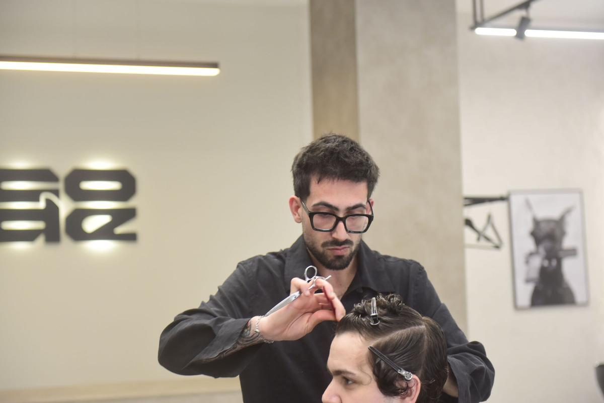 Carlos Xiri mientras realiza un corte de pelo en Code Studio, su local.