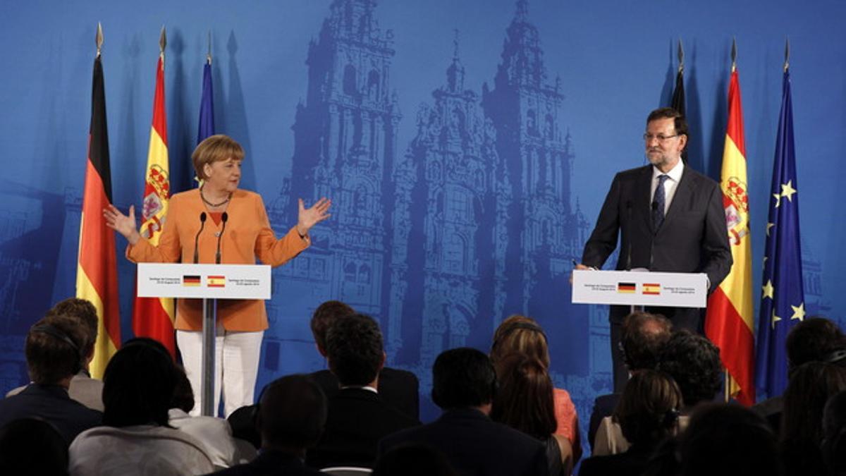 Rajoy y Merkel dan una rueda de prensa conjunta en Santiago, el pasado 25 de agosto.