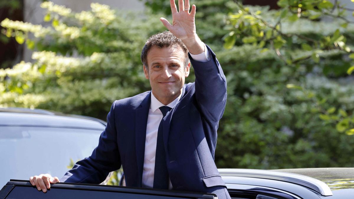 El presidente francés, Emmanuel Macron, saluda a simpatizantes tras votar, este domingo.