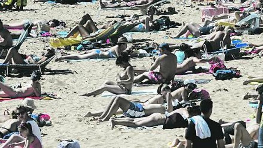 Gente disfrutando del sol, ayer, en el arenal de San Lorenzo.