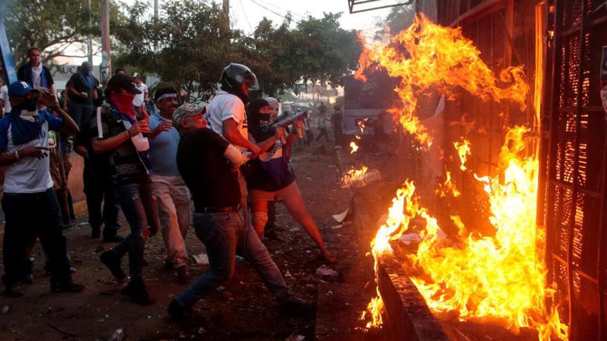 Manifestantes queman una radio en una protesta.