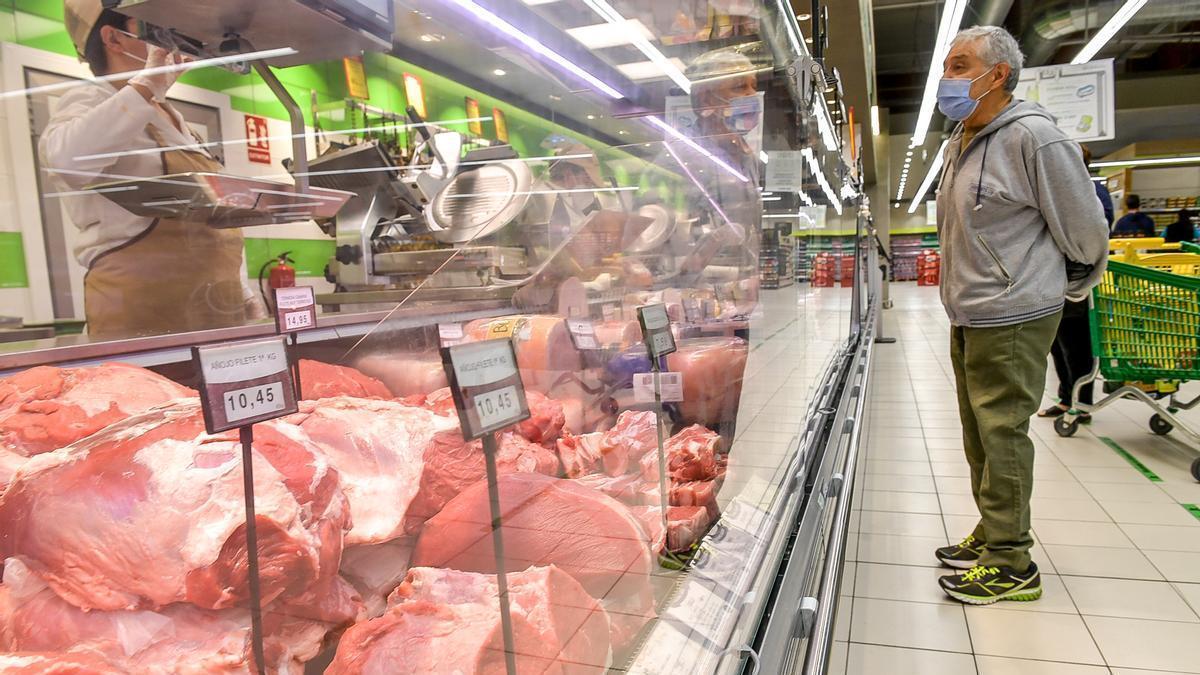 Un hombre compra en la carnicería de un supermercado.