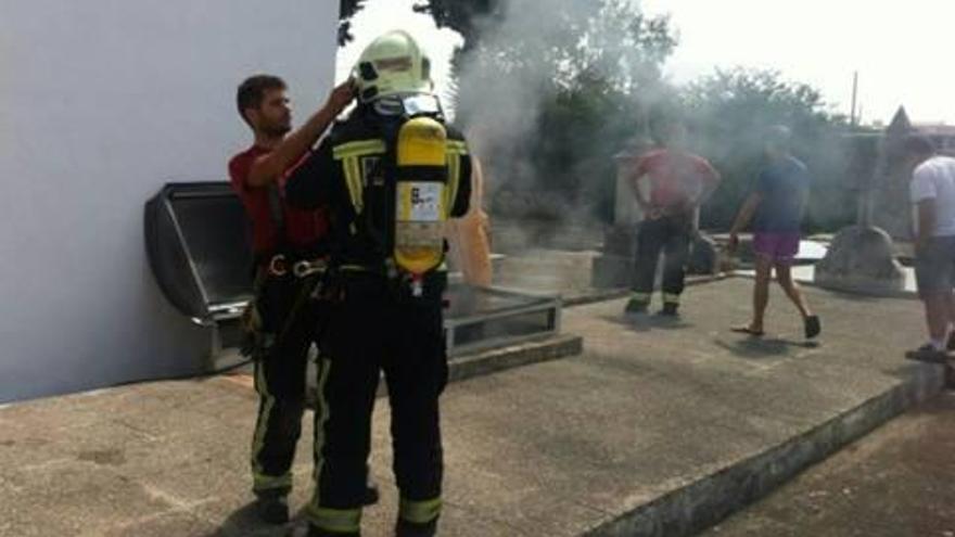 Los bomberos, equipados con equipos de respiración trabajan en sofocar el incendio.