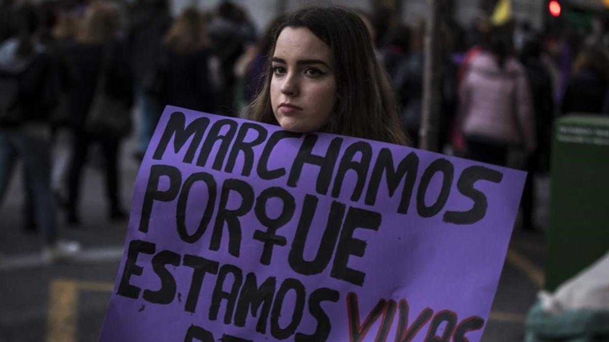 Uuna joven sostiene una pancarta contra la violencia machista, en la manifestación del 8-M, en Valencia.