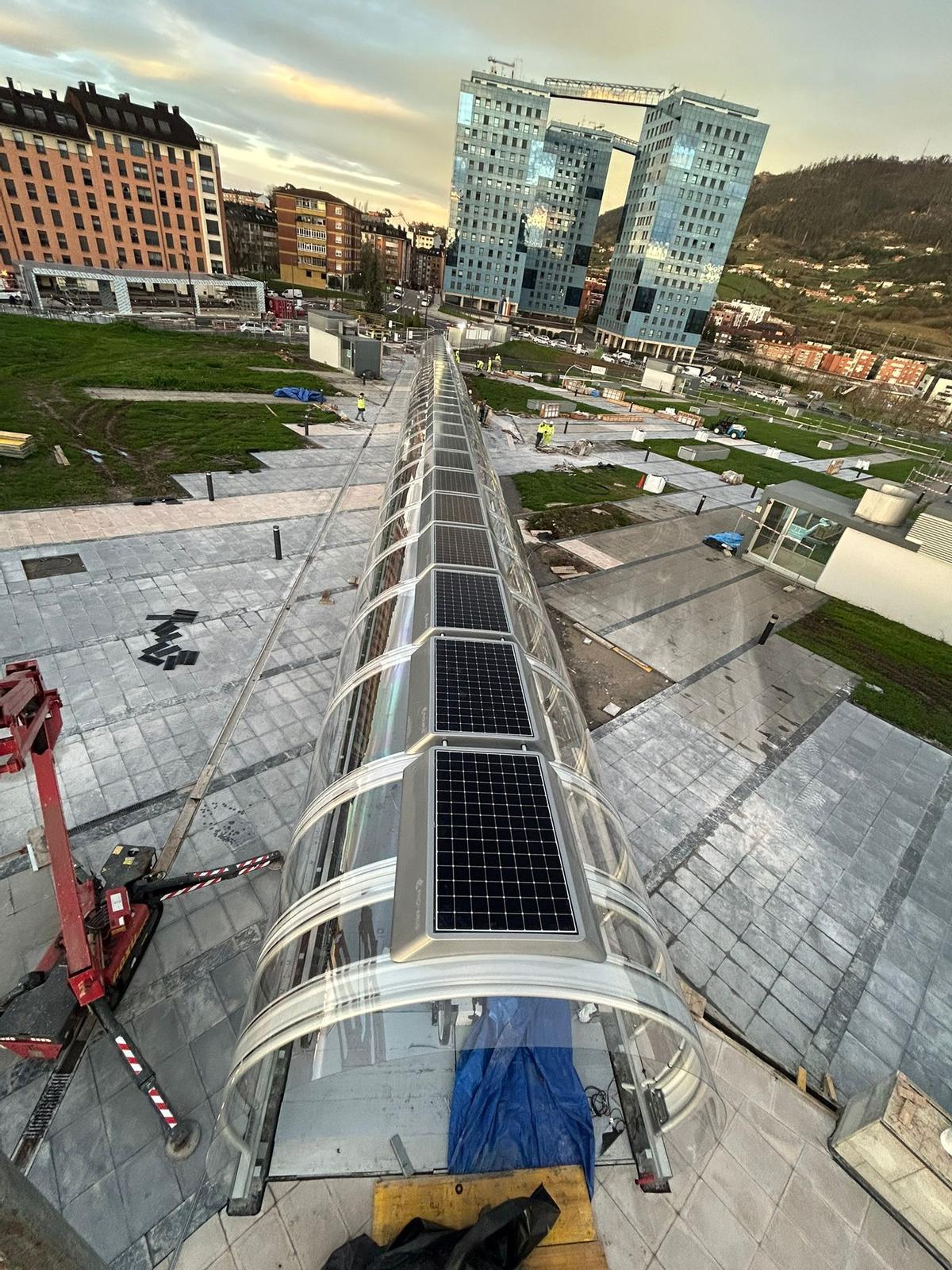 Los pasillos rodantes, con placas solares en las cubiertas, y al fondo a la izquierda, la gran marquesina.