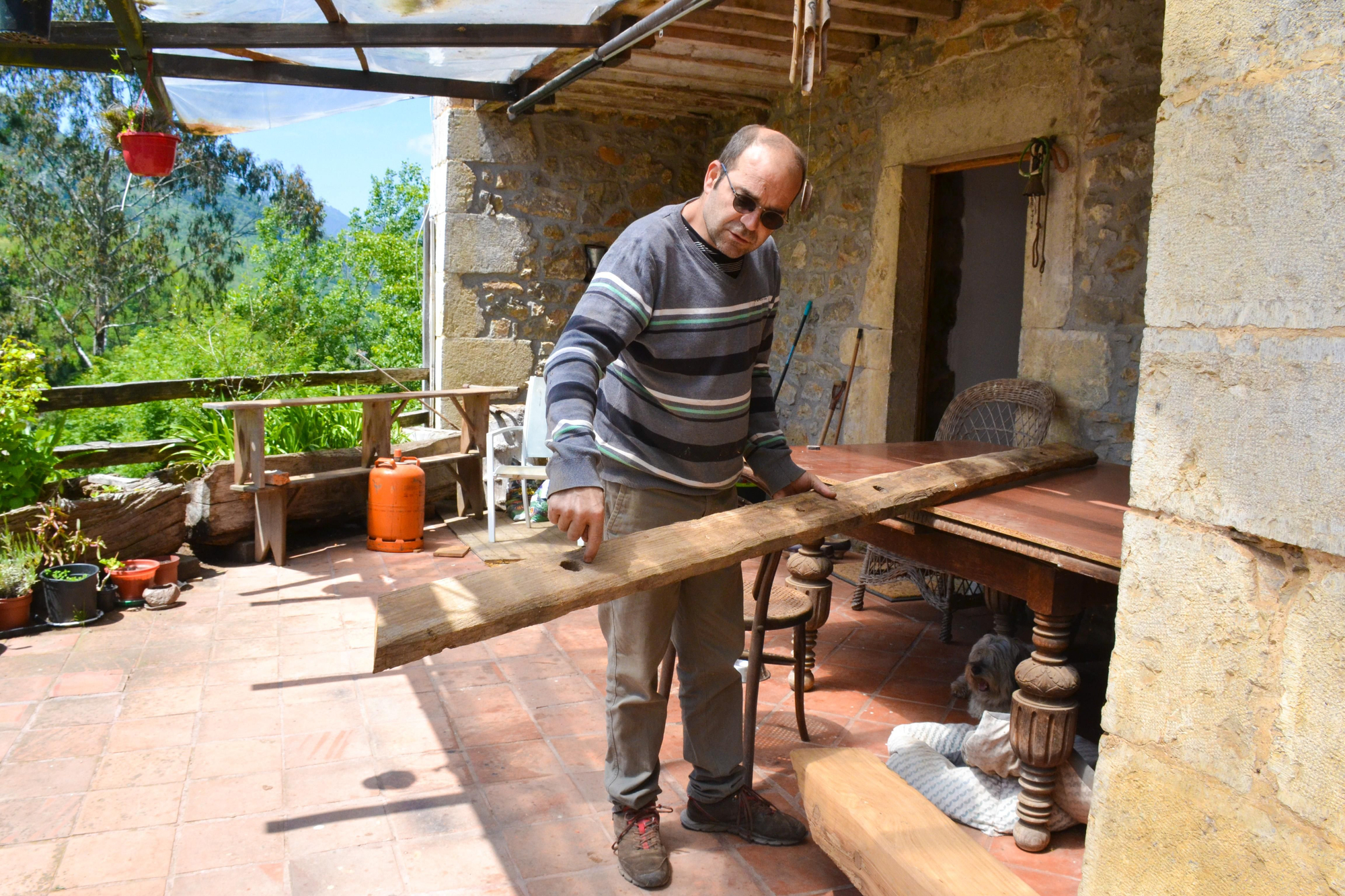 Santi Somoano muestra una pieza de un hórreo que está restaurando.