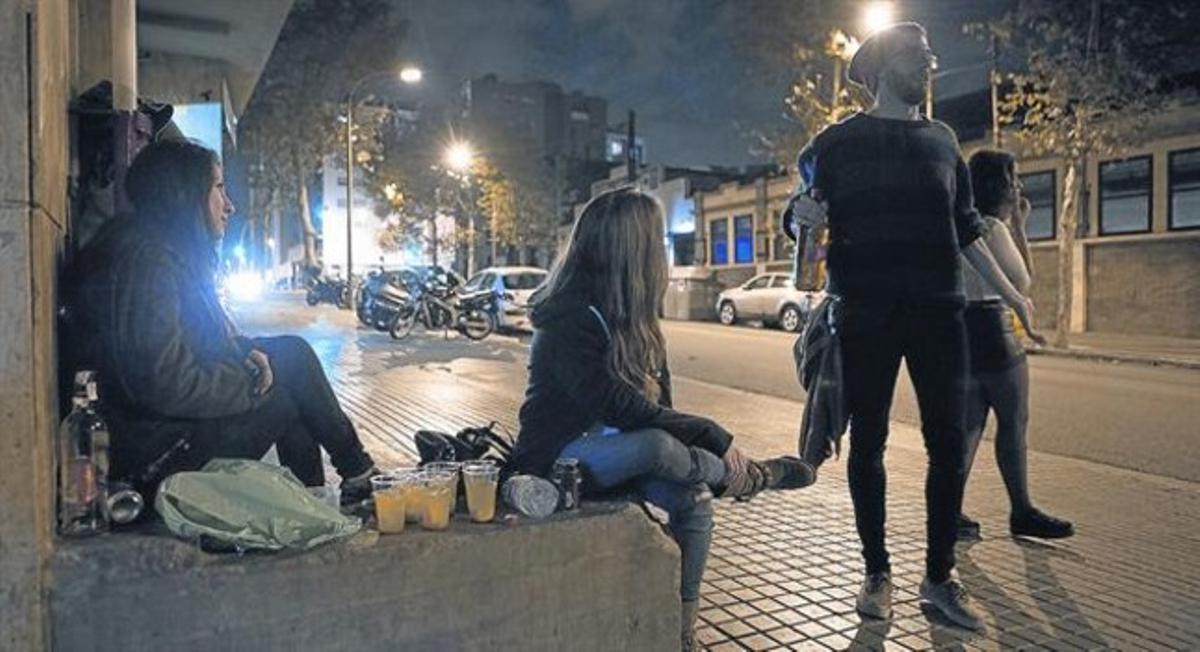 Un grup de joves consumeixen alcohol en un carrerdel Poblenou.