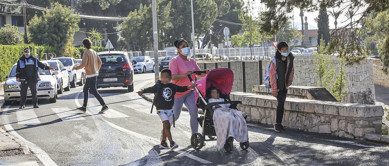 Escolares cruzan, este martes, en el entorno del Tossal, donde el paso de cebra se junta con una escalera de acceso al monte.