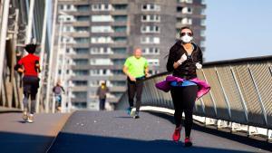 Un corredor con la máscara protectora cruza el puente Erasmus en Rotterdam, la misma fecha prevista para el maratón de Rotterdam, donde debido al brote mundial del nuevo coronavirus, la organización decidió posponer el evento en una fecha futura.