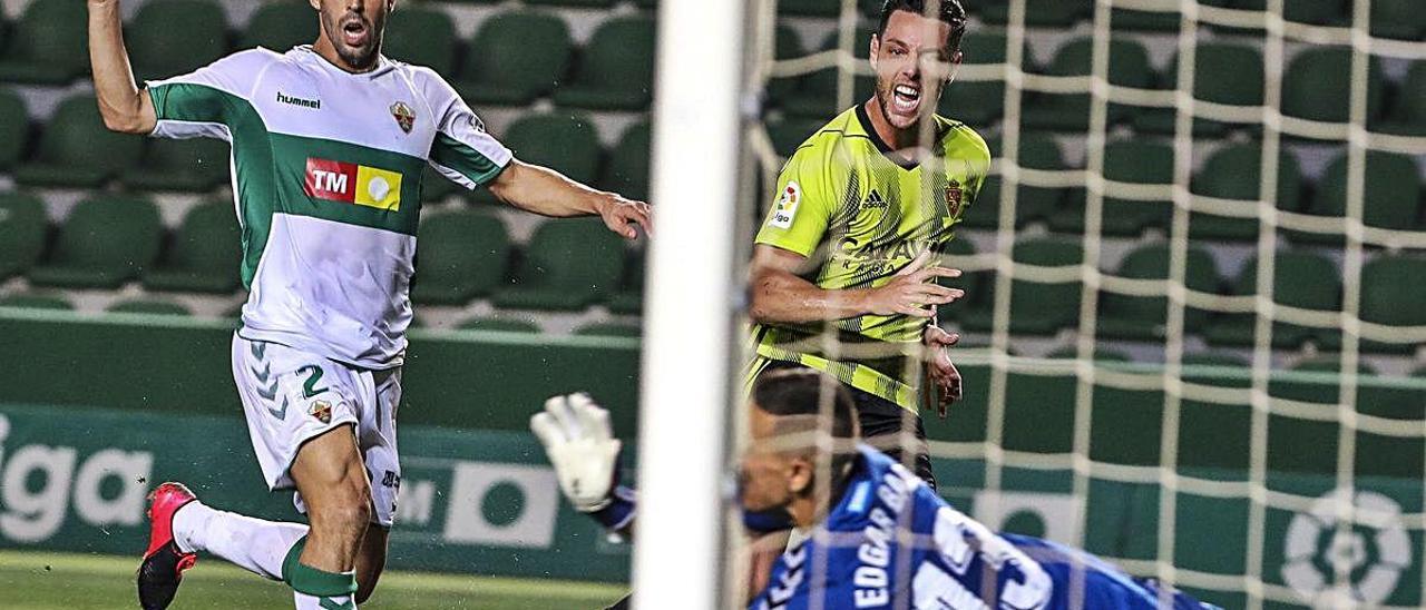 El portero del Elche Edgar Badia evita un gol de Burgui al filo del descanso.