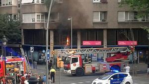 Los bomberos apagan el incendio declarado en la sede de UPDE, en el número 444 de la Gran Via de Barcelona.