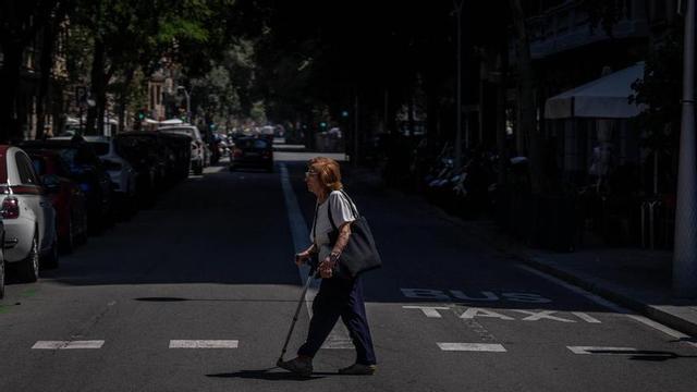Una persona camina sota el sol durant un dia d’onada de calor a Barcelona.