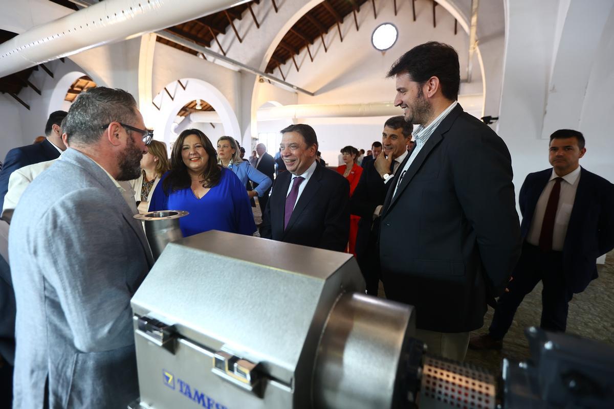 La alcaldesa de Montoro, Lola Amo, junto a Luis Planas y Pedro Fernández, delegado del Gobierno en Andalucía, conversan con un expositor.