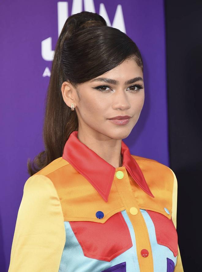 Zendaya con melena lisa recogida en una coleta alta con raya a un lado