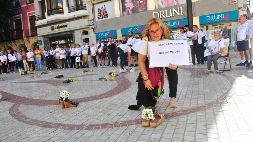 Una de las usuarias de Cáritas Elche con un cartel pidiendo más visibilidad hacia las personas sin techo