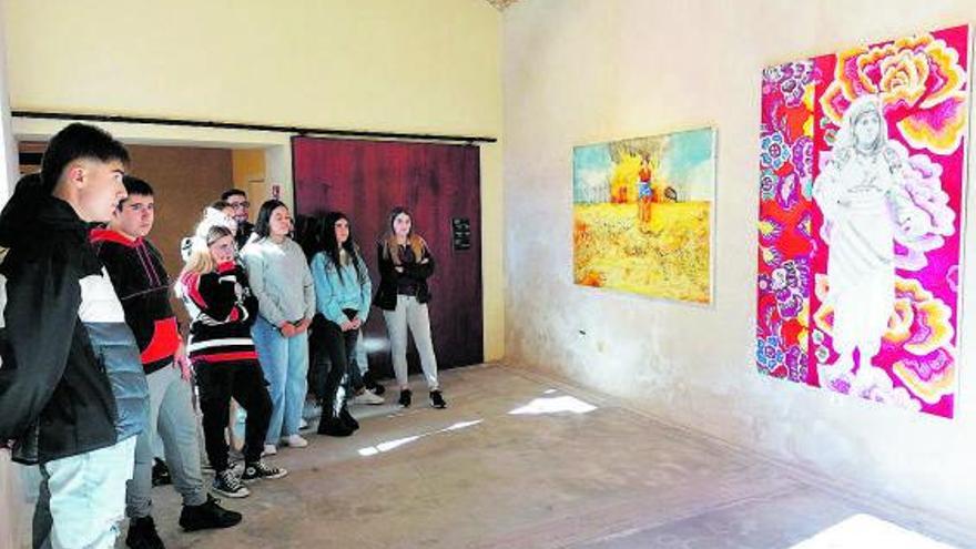 Jóvenes contemplan pinturas dedicadas a mujeres “guerreras” en una sala del Alcázar de Toro. | M. J. C.